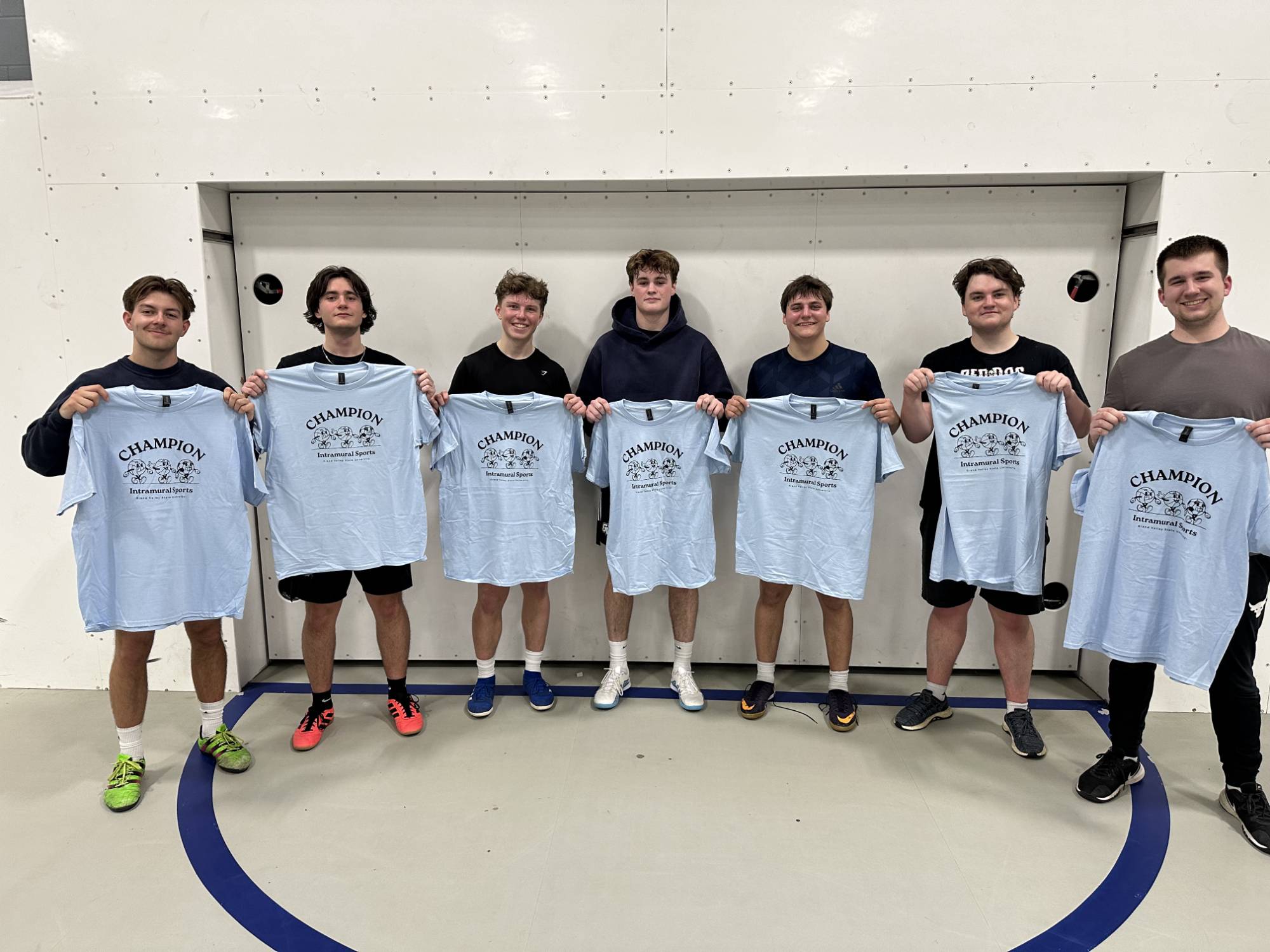 Grand valley students posing with championship t-shirt for winning the futsal bracket.